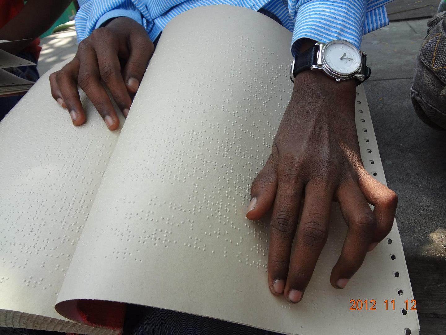 Student reading Braille with focused concentration